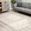 Modern living room with grey couch and patterned rug.