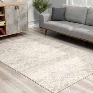 Modern living room with grey couch and patterned rug.