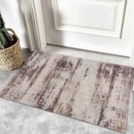 Rustic doormat on gray tiled floor near door.