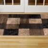 Checkered rug on wooden floor near door.