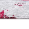 Gray rug with scattered red splashes, textured surface.