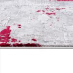Gray rug with scattered red splashes, textured surface.
