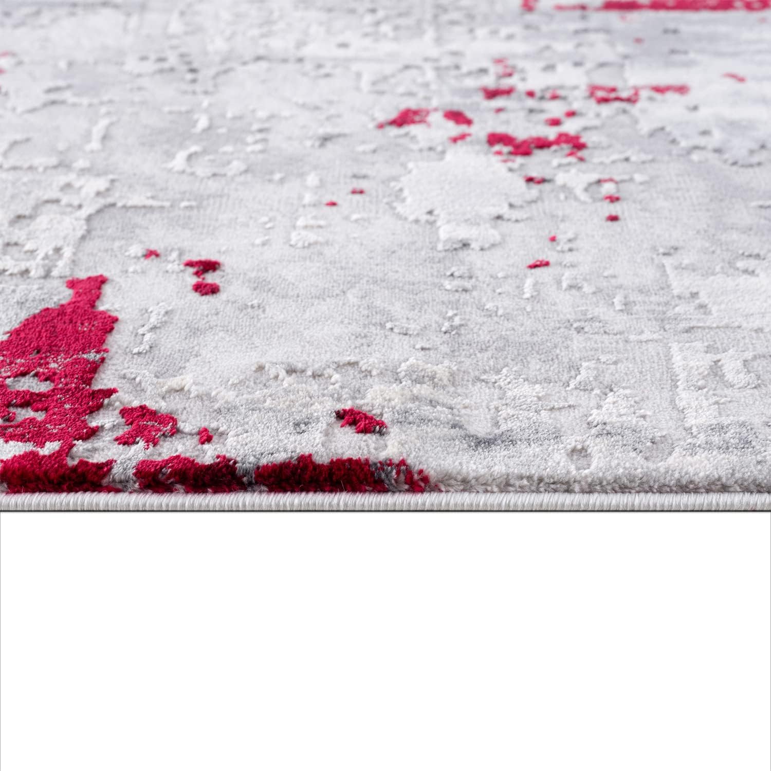 Gray rug with scattered red splashes, textured surface.