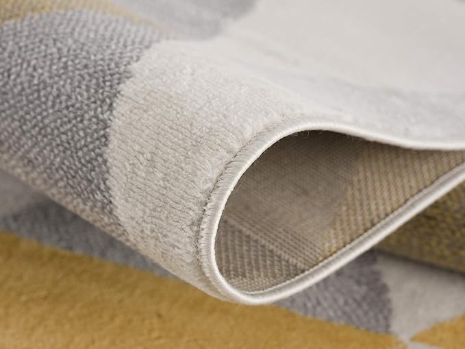 Close-up of folded gray and yellow area rug.