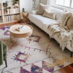 Cozy living room with colorful rug and plants.