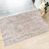 Marble-patterned rug on wooden floor near flowers.