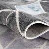 Geometric gray area rug with folded corner.