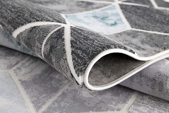 Geometric gray area rug with folded corner.