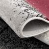 Close-up of rolled textured carpet with red accent.
