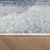 Close-up of textured rug on hardwood floor.