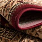 Close-up of rolled Persian carpet with intricate designs.