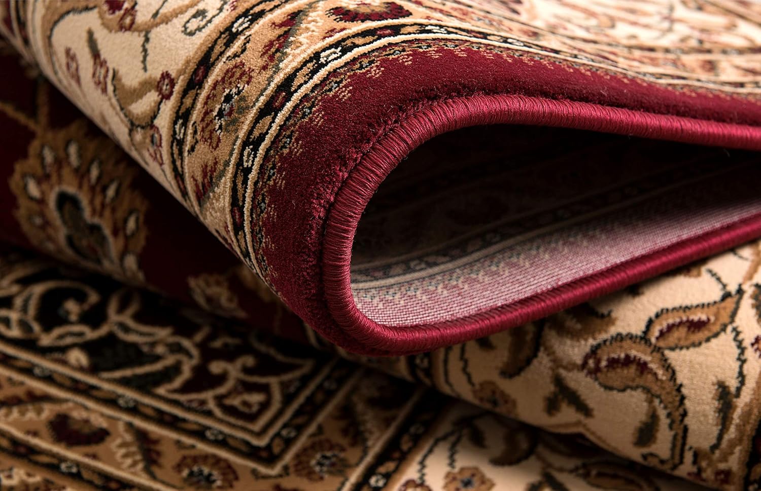 Close-up of rolled Persian carpet with intricate designs.