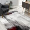 Modern living room with abstract rug and furniture.