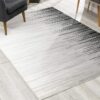 Modern ombre area rug on light wood floor.