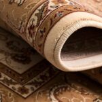 Close-up of rolled beige patterned rug