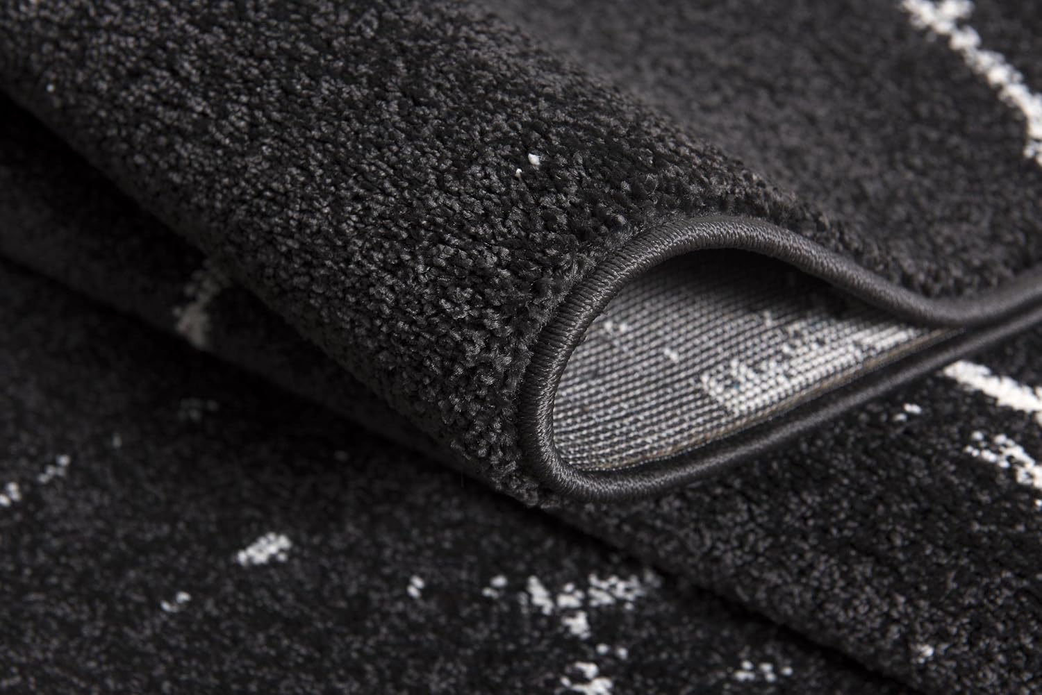 Close-up of folded black textured carpet