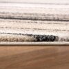 Close-up of patterned carpet on wooden floor.