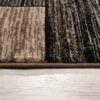 Close-up of patterned carpet edge on wooden floor.