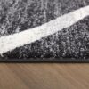 Close-up of gray textured rug on wooden floor.