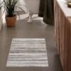 Modern bathroom with striped rug and plant