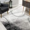 Modern living room with patterned rug and armchair.