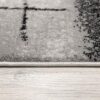 Close-up of textured rug on wooden floor.