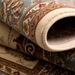 Close-up of rolled oriental rug with floral patterns.