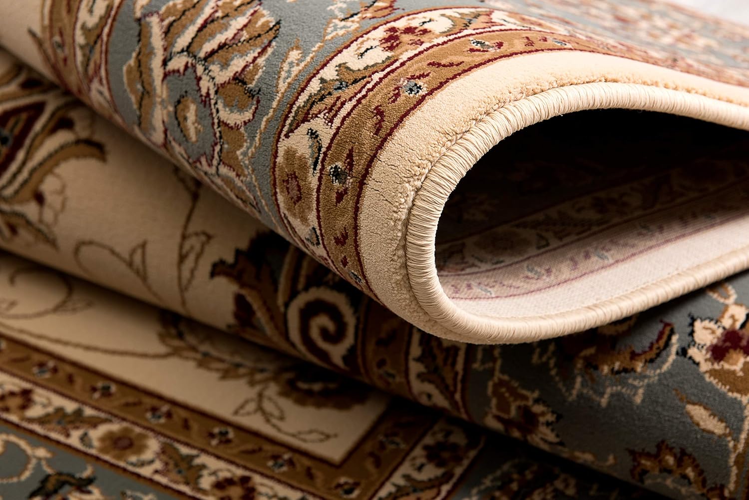 Close-up of rolled oriental rug with floral patterns.