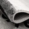 Close-up of rolled black and white textured rug.