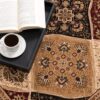 Open book and coffee on decorative rug.