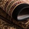 Rolled ornate patterned carpet in detail.