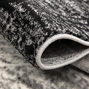 Close-up of a folded, textured black and white rug.
