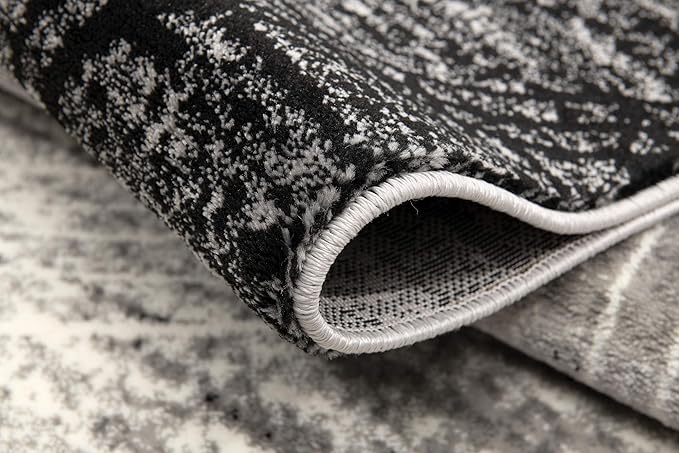 Close-up of a folded, textured black and white rug.