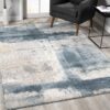 Modern abstract blue and gray area rug in room.