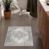Stylish bathroom with decorative floor rug and plant