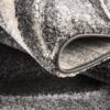 Close-up of gray and white rug corner.