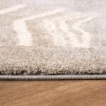 Close-up of beige carpet on wooden floor.