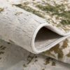 Folded patterned area rug in neutral tones.