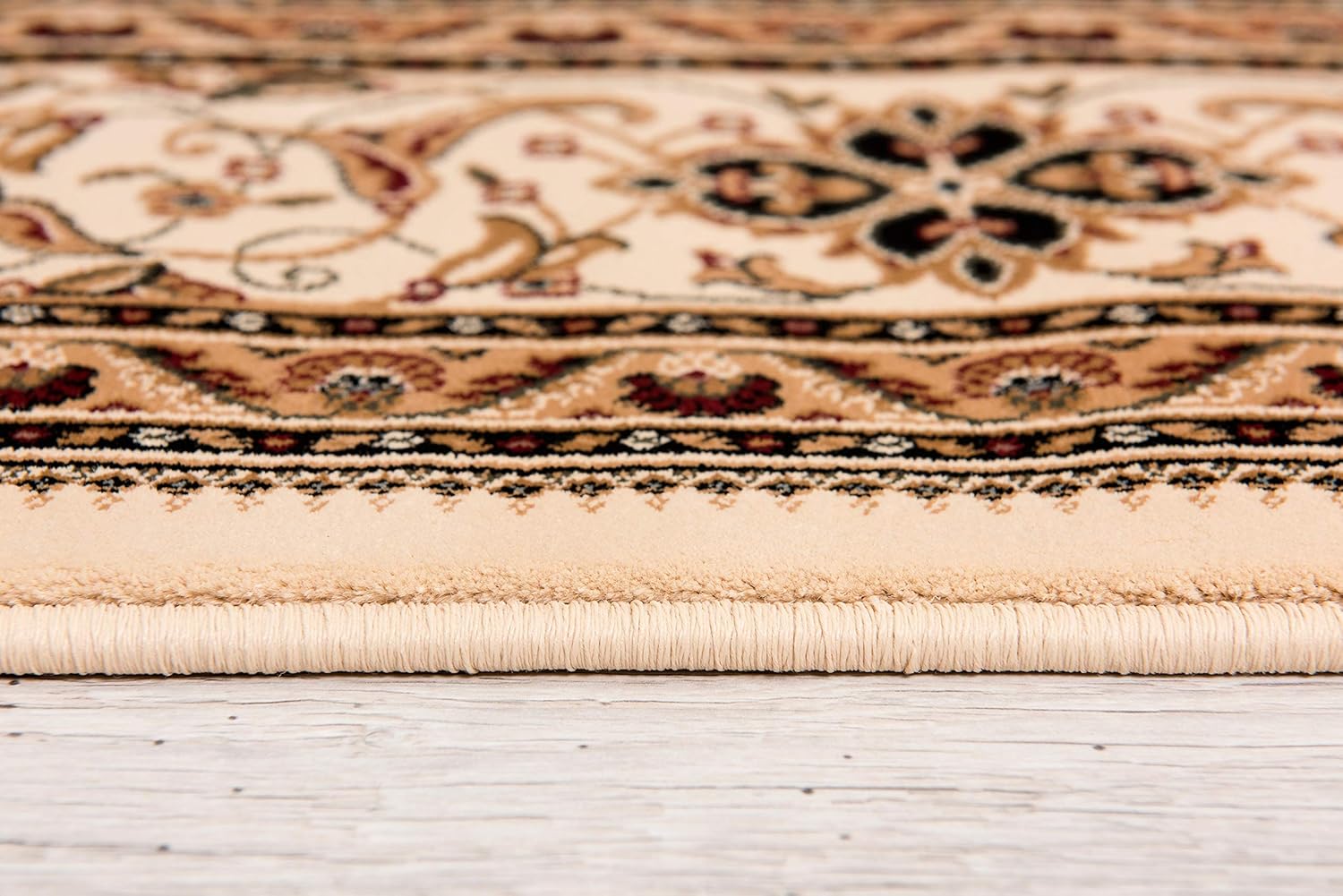 Close-up of ornate beige patterned carpet edge