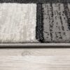 Close-up of modern rug on wooden floor.