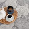 Tea set on woven placemat with candle and cup.