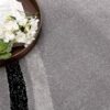 Book and flowers on gray patterned rug.