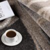 Cozy coffee on patterned rug with book and wheat.