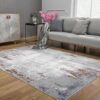 Modern living room with gray couch and abstract rug.
