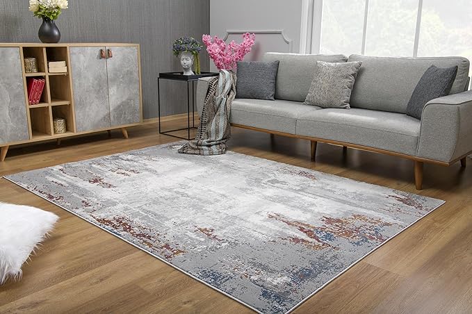 Modern living room with gray couch and abstract rug.