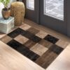 Geometric brown and black checkered rug by door.