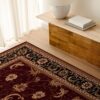 Elegant Persian rug beside wooden table and lamp.