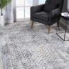 Modern living room with patterned rug and gray chair.
