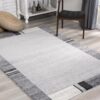 Modern gray rug with geometric pattern on floor.