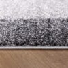 Close-up of gray and black textured carpet edge.